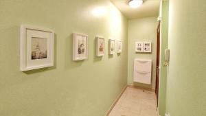 a hallway with pictures on the walls of a bathroom at Apartamento con wifi en casco histórico Betanzos in Betanzos