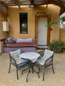 eine Terrasse mit 2 Stühlen, einem Tisch und einem Sofa in der Unterkunft cozy room in Mitzpe Ramon