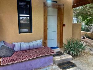 a couch sitting outside of a house with a door at cozy room in Mitzpe Ramon