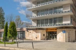 un bâtiment avec un parking en face de celui-ci dans l'établissement Rzemieślnik Zakopane, à Zakopane