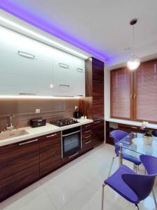 eine Küche mit lila Stühlen und einem Glastisch in der Unterkunft Apartament Blisko Centrum in Kielce