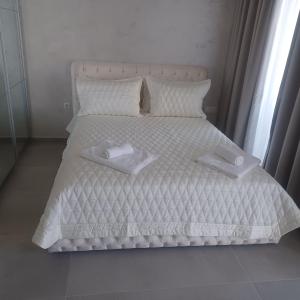 Una cama blanca con dos toallas blancas. en Romantic Holiday Studio en Saints Constantine and Helena