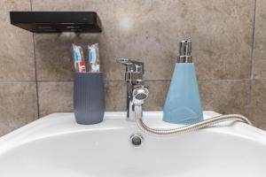 un lavabo de salle de bain avec un porte-brosse à dents et un robinet dans l'établissement YourHouse на Си Синхая 22 близко к Меге, à Almaty
