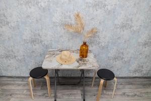 a table with a hat and two chairs at YourHouse на Си Синхая 22 близко к Меге in Almaty