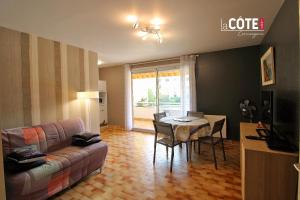 ein Wohnzimmer mit einem Sofa und einem Tisch in der Unterkunft LE CORVETTE 1 - 4 COUCHAGES in Carry-le-Rouet