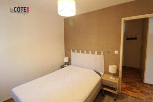 a bedroom with a white bed and a lamp at LE CORVETTE 1 - 4 COUCHAGES in Carry-le-Rouet