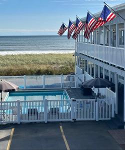 a building with american flags on the beach at On the Beach Motel in Old Orchard Beach