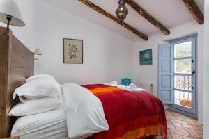a bedroom with a bed with a colorful blanket at Casa Higueras in Moclín