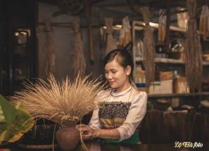 una mujer está de pie junto a una olla de hierba en Muonglo Farmstay, en Yên Bái