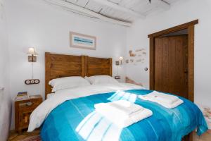 a bedroom with a large bed with towels on it at Casa Higueras in Moclín