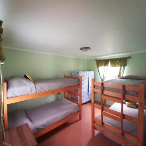 a room with three bunk beds and a window at Cabañas Alma Changa Atacama in Caldera