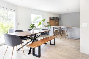 Chambre Lumineuse Dans Une Maison Moderne في Treyvaux: مطبخ وغرفة طعام مع طاولة وكراسي خشبية
