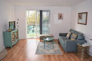 a living room with a couch and a tv at Urban Gem Apartment- Free parking in Enfield