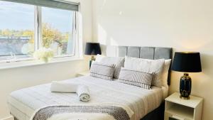 a bedroom with a large bed with a window at Urban Gem Apartment- Free parking in Enfield