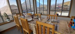 comedor con mesa, sillas y ventanas en Casa Adriano & Filomena, en Portela