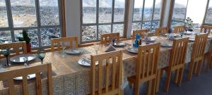 comedor con mesa, sillas y ventanas en Casa Adriano & Filomena, en Portela