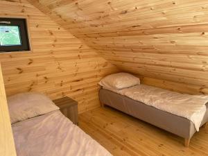 Un pat sau paturi într-o cameră la Całoroczne Chatki Raju