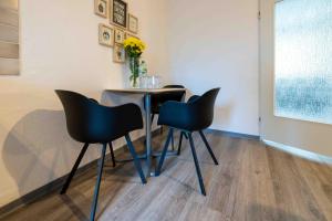 a table with four chairs and a vase of flowers at Messe Apartment Neuss Düsseldorf in Neuss