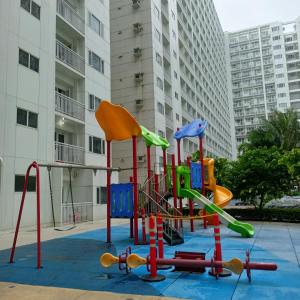 a playground in front of a apartment building at Chillax Condotel - Shore Residences in Manila