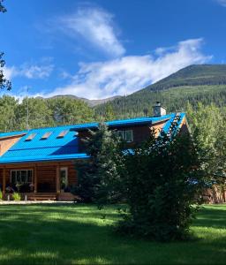 uma casa com painéis solares na lateral em Cougar Mountain Cabin Rentals em Valemount