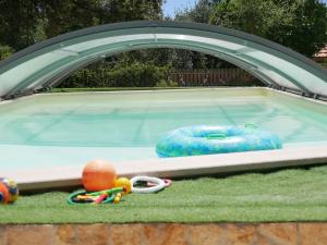 a swimming pool with a trampoline and toys in the grass at Quinta das Cantigas by Book YourHoliday PT in Aljubarrota