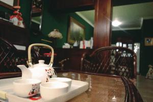 un tavolo con due tazze e un bollitore per il tè sopra di 似層-宜蘭夜市旁老屋包棟民宿-臉書訂房兩人3000元 a Città di Yilan
