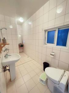 a white bathroom with a toilet and a sink at 似層-宜蘭夜市旁老屋包棟民宿-臉書訂房兩人3000元 in Yilan City