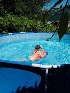 a young child in a swimming pool with a life vest at Grădina cu povești in Brezoi