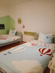 a bedroom with two beds with red and white sheets at Grădina cu povești in Brezoi