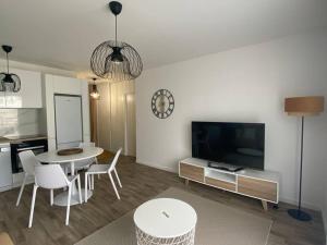 een woonkamer met een tafel en een tv bij Fantastique 2 pièces à Créteil in Créteil