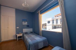 a bedroom with a bed and a large window at Pensión La Gaviota in Playa de Santiago +22 photos