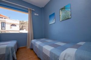 1 Schlafzimmer mit 2 Betten und einem großen Fenster in der Unterkunft Pensión La Gaviota in Playa de Santiago