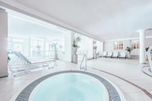 - une grande piscine dans une pièce avec terrasse couverte dans l'établissement Gourmet & Wine Hotel Austria - 4 Sterne superior, à Obergurgl