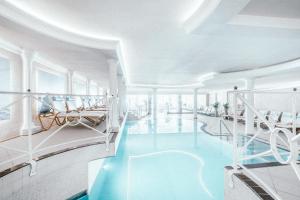 a swimming pool with blue water in a building at Gourmet & Wine Hotel Austria - 4 Sterne superior in Obergurgl