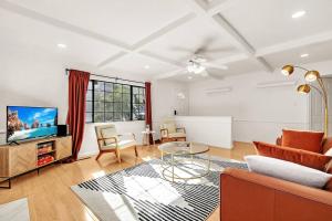 a living room with a couch and a tv at King Suite, 5 Queen beds Spacious Modern Home in Castro Valley