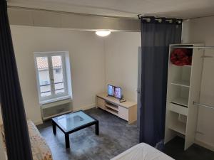 een kleine woonkamer met een tafel en een televisie bij APPARTEMENT Duo in Port-la-Nouvelle