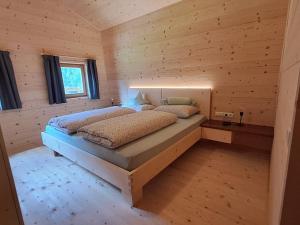 een slaapkamer met een bed in een houten hut bij Bergchalet Englhof in Moso