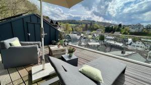 a balcony with a patio furniture and an umbrella at Williadukt in Willingen