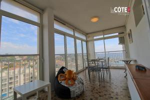 a living room with large windows and a table and chairs at Le Briand in Carry-le-Rouet