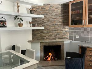 a living room with a fireplace with chairs and a table at A Casa da Azenha in Sertã