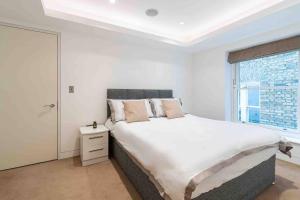 een witte slaapkamer met een groot bed en een raam bij London Mayfair W1 in Londen