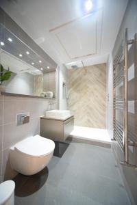 a bathroom with a toilet and a sink at Stylish 1BR - Bright & Large Living Area w/ Patio in London