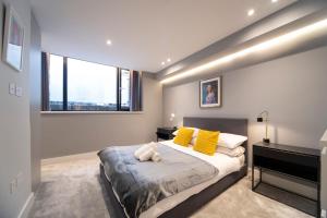 ein Schlafzimmer mit einem Bett mit gelben Kissen und einem Klavier in der Unterkunft Stylish 1BR - Bright & Large Living Area w/ Patio in London
