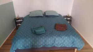 Una cama en una habitación con dos bolsas. en Plein centre, en Malzéville