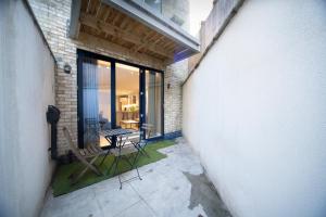 a balcony with a table and chairs in a building at Stylish 1BR - Bright & Large Living Area w/ Patio in London