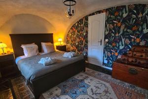 - une chambre avec un lit et un papier peint floral dans l'établissement Exceptional stone mountain house, à Saint-Michel-de-Maurienne
