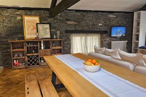 - un salon avec une table en bois et un bol de fruits dans l'établissement Exceptional stone mountain house, à Saint-Michel-de-Maurienne