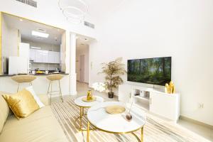 ein Wohnzimmer mit Sofa und Fernseher in der Unterkunft Luxury 1 Bedroom On Marina Walk, Sleeps 6, 1 Min to Metro in Dubai