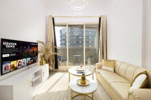 a living room with a couch and a tv at Luxury 1 Bedroom On Marina Walk in Dubai