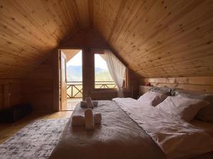 duże łóżko w pokoju z dużym oknem w obiekcie House in the clouds&სახლი ღრუბლებში w mieście Kʼveda Chʼkhutunetʼi